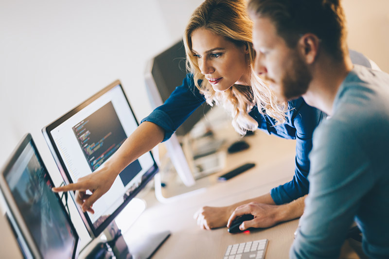 A Woman and a Man Editing Photos