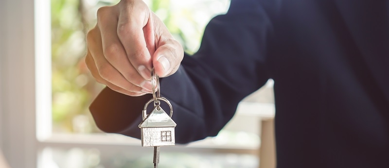 A Realtor Giving a Key from a House to a Buyer