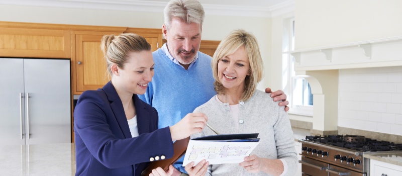 A Realtor Showing Prospects a Property Brochure